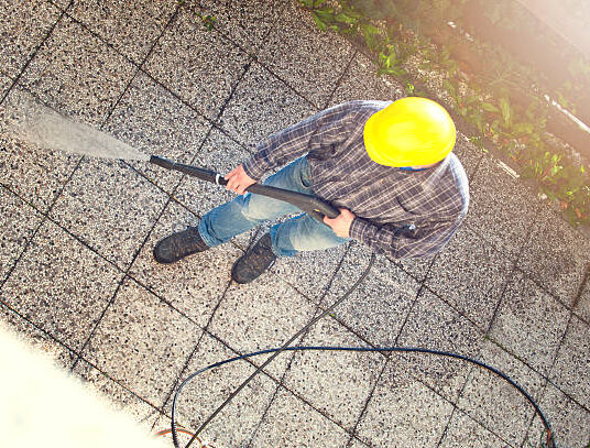 Man cleaning the back yard with high pressure washer