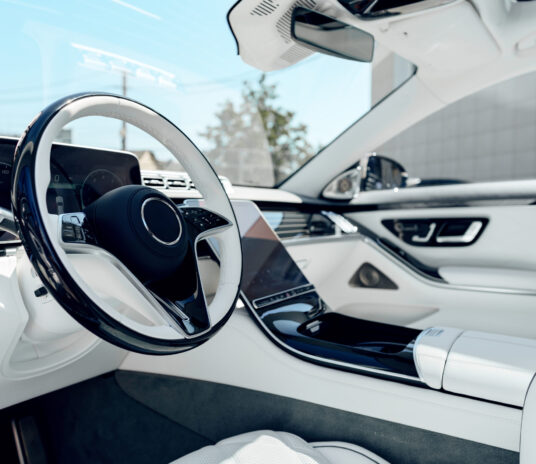 Vehicle interior showcases a sleek, modern design with high-tech dashboard elements.